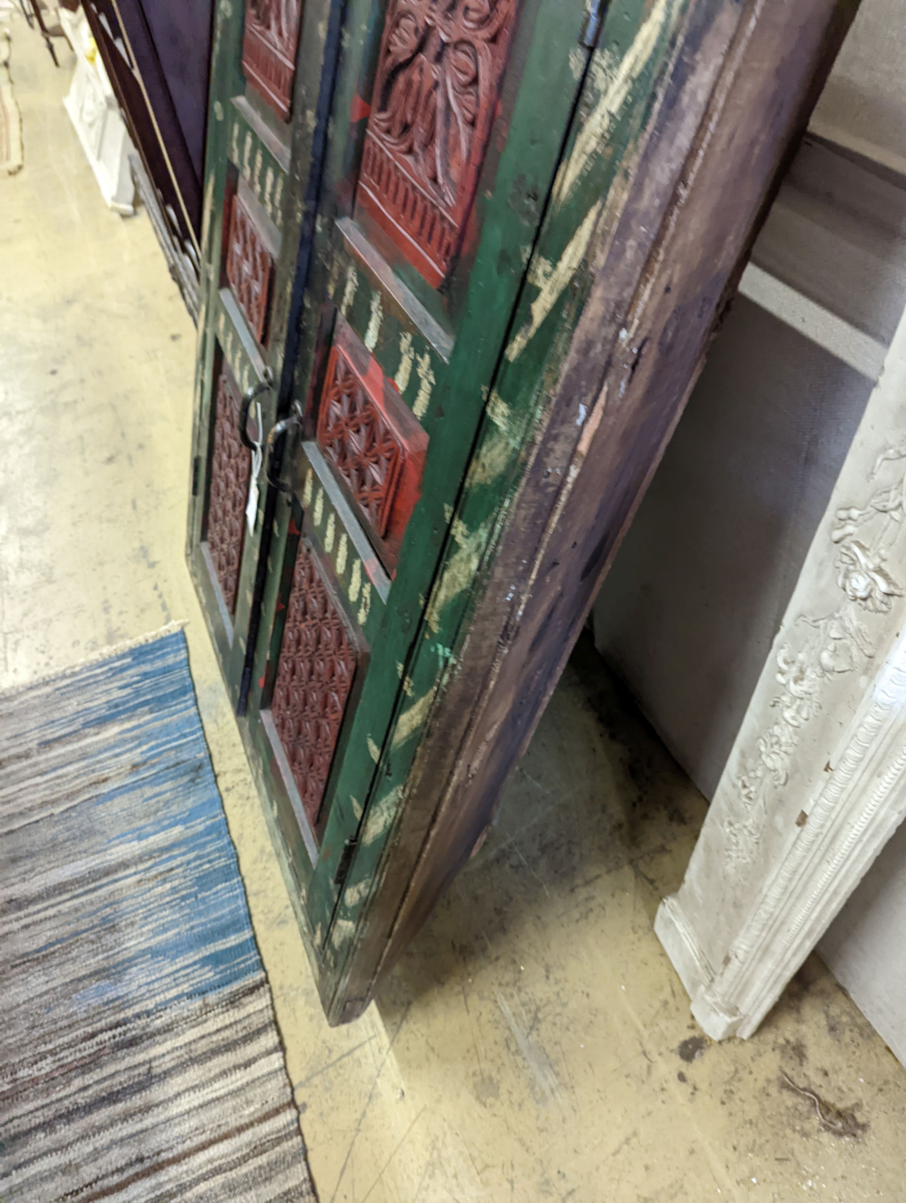 An Indian painted carved hardwood corner cupboard, width 90cm, height 131cm